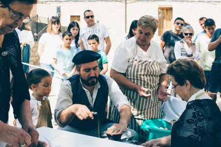 PUERTOMINGALVO, TERUEL, SPAIN - AUGUST 5, 2018: Group of men and women making handcraft sausage during an exhibition celebrated in a medieval fair in Puertomingalvo, a small town located in the Maestrazgo Cultural Park in the region of Gudar Javalambre, iのeditorial素材