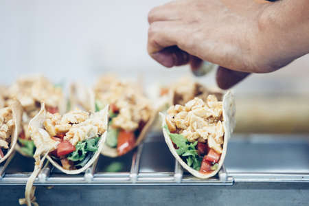Detail of a the hands of a chef preparing tasty typical spanish tapas served on pita breadの写真素材