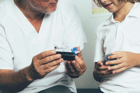 Cropped view of a doctor explaining to a young diabetic patient the insertion system of the infusion...