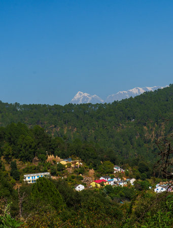 Village in the mountains on a background of the blue sky and snow peaks