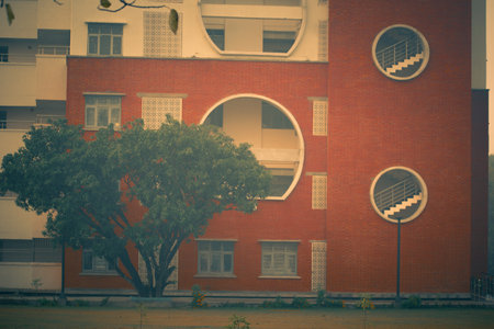 red brick building with green tree - retro vintage effect style pictures.の写真素材
