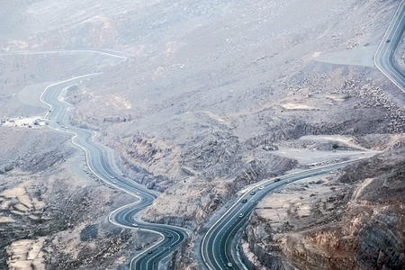 Geological landscape of Jabal Jais characterised by dry and rocky mountains, Road between mud...