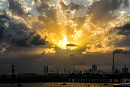 Scenic sunset and natural dramatic cloudy sky and sunbeam view over Dubai, United Arab Emiratesの写真素材