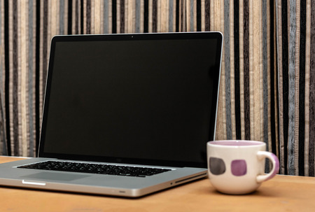 Laptop Computer With Black Screen On The Table In Office Along With A Coffee Cupの写真素材