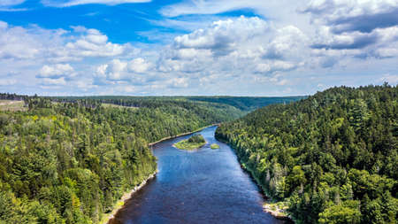 Drone View of Green Mountain Landscape, Summer Season in Canada, Water Stream flowing between Forest.の写真素材