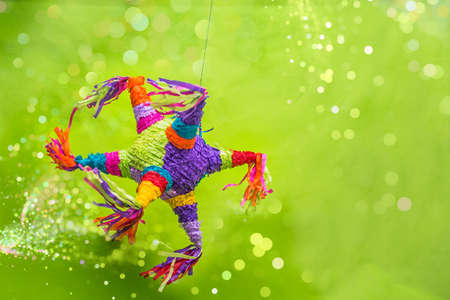 mexican piÃ±ata party hanging on blue and green background with multi-colored glitters celebrating birthday, christmas, party, party songs, figure in the shape of star and donkey, family funの写真素材