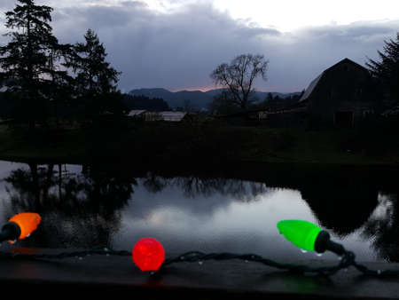 Christmas lights in front of pond and barn on CHristmas Morningの写真素材