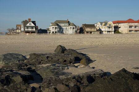 A row of houses along the rocky beach.