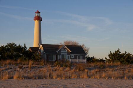 A lighthouse behind the sand dunes.の写真素材