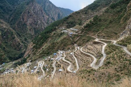 A winding mountain road lined with the houses of a small village.の写真素材