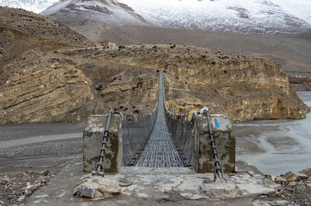 A long swinging bridge over an expansive river gorge.の写真素材