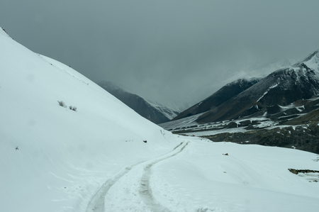 Vehicle tracks on a snow covered road in the Himalaya Mountain Range.