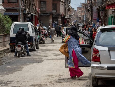 Kathmandu, Nepal - April 7, 2019: A woman getting out of a car in the UNESCO World Heritage Site of Patan Durbar Marg in Kathmandu, Nepal on April 7, 2019.のeditorial素材