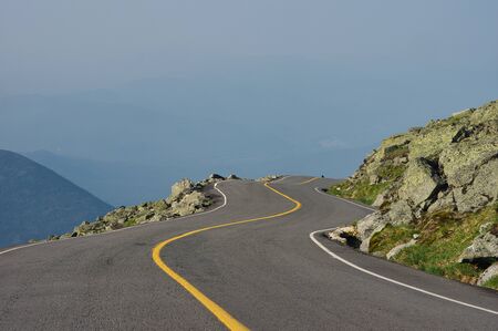 A paved road winding around the side of a mountain.の写真素材