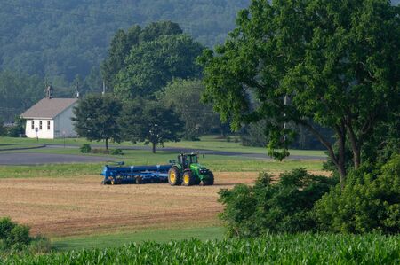Denver, Pennsylvania - June 29, 2019: Farmer working in the fields planting in Denver, Pennsylvania...