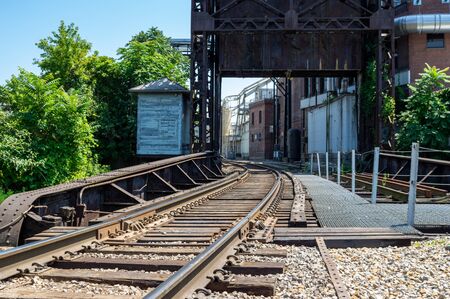 A railroad running on the backside of some warehouse buildings.