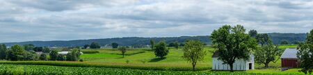 The beautiful green farmland of Lancaster County, Pennsylvania with a farm in the background.