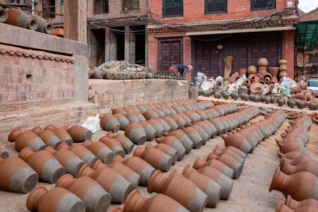 Bhaktapur, Nepal - November 17, 2019: A man putting pottery outside to dry in the sun before putting it in the kiln.のeditorial素材