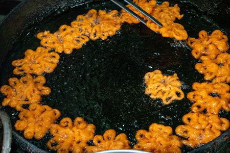 Making some jelabi sweets in the frying pan.