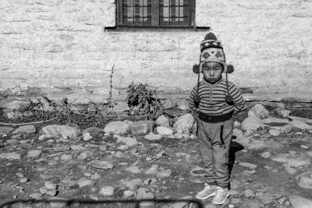 Mustang, Nepal - November 10, 2019: A yopung Nepali boy standing by the roadside in the Mustang...