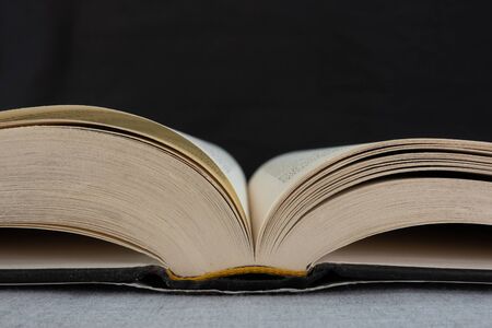 An open book lying on a table with a background.の写真素材