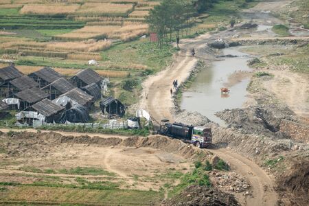 An old pitch Truck on a Dirt Road Beside a River in Nepal.