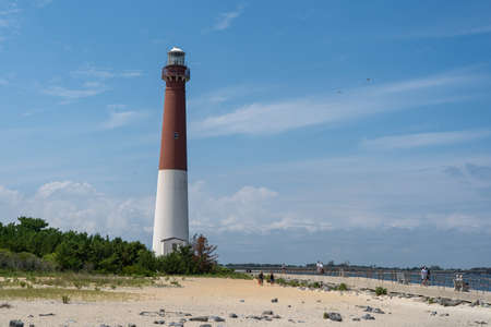 A view of the majestic Barnegat Lighthouse on the shore.の写真素材