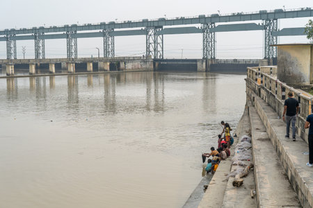 Koshi, Nepal - October 22, 2021: Children fishing with the Koshi River Barrage Bridge in the background.のeditorial素材