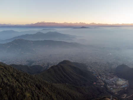A heavy layer of smog covering the city of Kathmandu, Nepal with the Himalaya Mountains bathed in the morning light.の写真素材