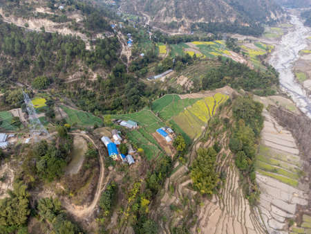 An aerial view of terraces and fields on a hillside in Nepal.