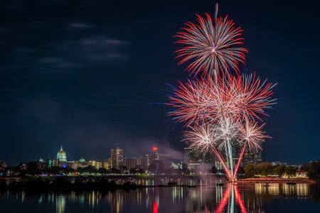 Harrisburg, Pennsylvania - July 4, 2022: A view of the July 4th fireworks over the city of Harrisburg with them reflecting in the Susquehanna River.のeditorial素材