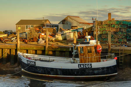 Fishing boat by the quayside seen in Brancaster Staith, Norfolk, UK. Taken 3rd Dec 2019.のeditorial素材