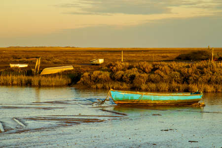 A row boat on the mud at low tide seen at Brancaster Staith, Norfolk, UK. Taken 3rd Dec 2019.のeditorial素材