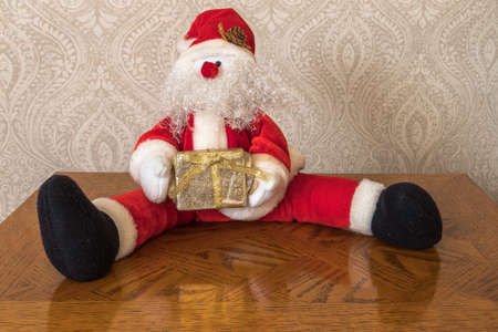 Fathe Christmas sitting on table with present in hands, Taken in KIngs Lynn, Norfolk, UK, on 23rd Dec 2019.のeditorial素材