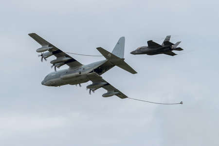 Lockheed C-130 with refueling pipes reployed being closely followed by a Lockheed Martin F-35...