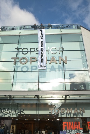 The Occupy Exeter banner saying "Tax Dodger 1.4bn" hangs down the front of the Exeter Branch of Topshop.のeditorial素材
