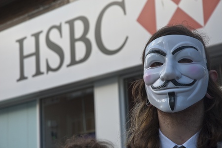 Occupy Exeter activist wearing a Guy Fawkes mask campaigning outside the Exeter branch of HSBC bankのeditorial素材