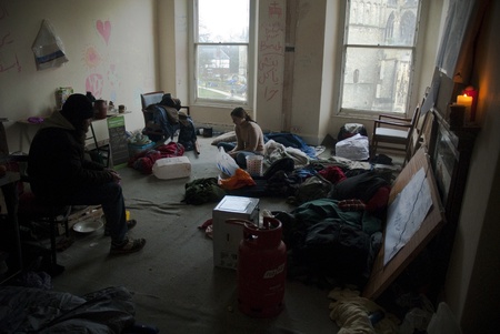 Occupy Exeter activist sit in the Guard Room of Occupy Exeter site 2 overlooking Exeter Cathedral Green.のeditorial素材