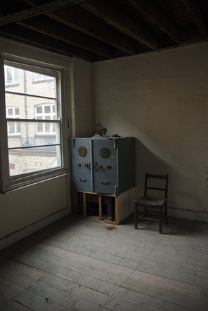 One of the rooms in Occupy Exeter site 2 that contains a large safe and a chair.のeditorial素材
