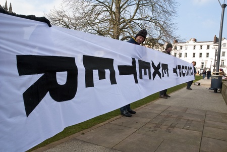 The huge Occupy Exeter banner is unfurled and displayed in front of Exeter Cathedral during Occupy...