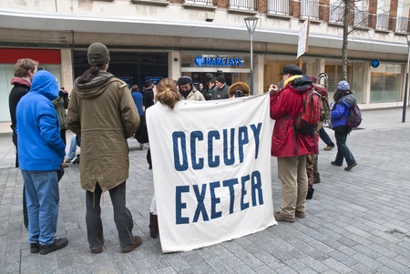 Occupy Exeter activist take part in a  general assembly meeting outside the Exeter branch of Barclays Bank.のeditorial素材
