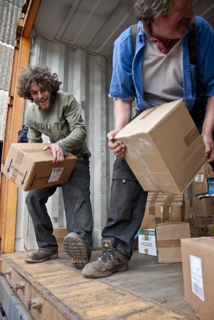 Volunteers from BookCycle stack boxes inside the container that is taking donated books to Ghana