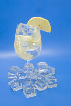 A cool lemony drink with ice and lemon slicesの写真素材