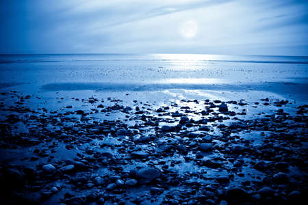 The rising moon reflected in the ocean from a beautiful bayの写真素材
