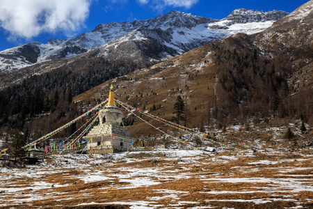 White Tibetan Prayer Stupa, Tibetan Prayer Flags - Picturesque winter scenery - Four Girls Mountain National Park in Sichuan Province, China. Shuangqiao Valley, Snow Capped Mountains. Siguniangshanのeditorial素材