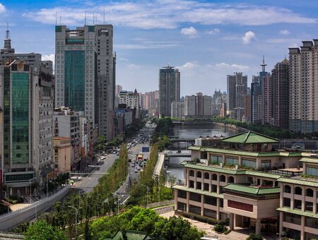Nanchang City - China Metropolis, Jiangxi Province China. City Skyline, skyscrapers and Chinese pagoda architecture in foreground. Modern downtown city area with dense clusters of buildings. Blue Skyのeditorial素材