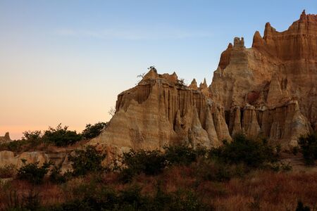 Earth Forest of Yuanmou in Yunnan Province, China - Exotic earth and sandstone formations glowing in the sunlight. Naturally formed pillars of rock and clay with unique erosion patterns. China Travelの写真素材