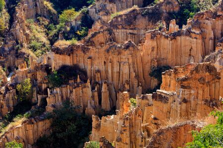 Earth Forest of Yuanmou in Yunnan Province, China - Exotic earth and sandstone formations glowing in the sunlight. Naturally formed pillars of rock and clay with unique erosion patterns. China Travelの写真素材