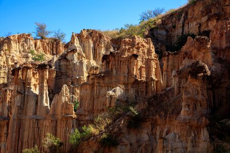 Earth Forest of Yuanmou in Yunnan Province, China - Exotic earth and sandstone formations glowing in the sunlight. Naturally formed pillars of rock and clay with unique erosion patterns. China Travelの写真素材