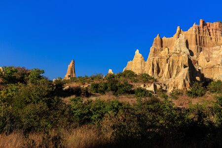 Earth Forest of Yuanmou in Yunnan Province, China - Exotic earth and sandstone formations glowing in the sunlight. Naturally formed pillars of rock and clay with unique erosion patterns. China Travelの写真素材
